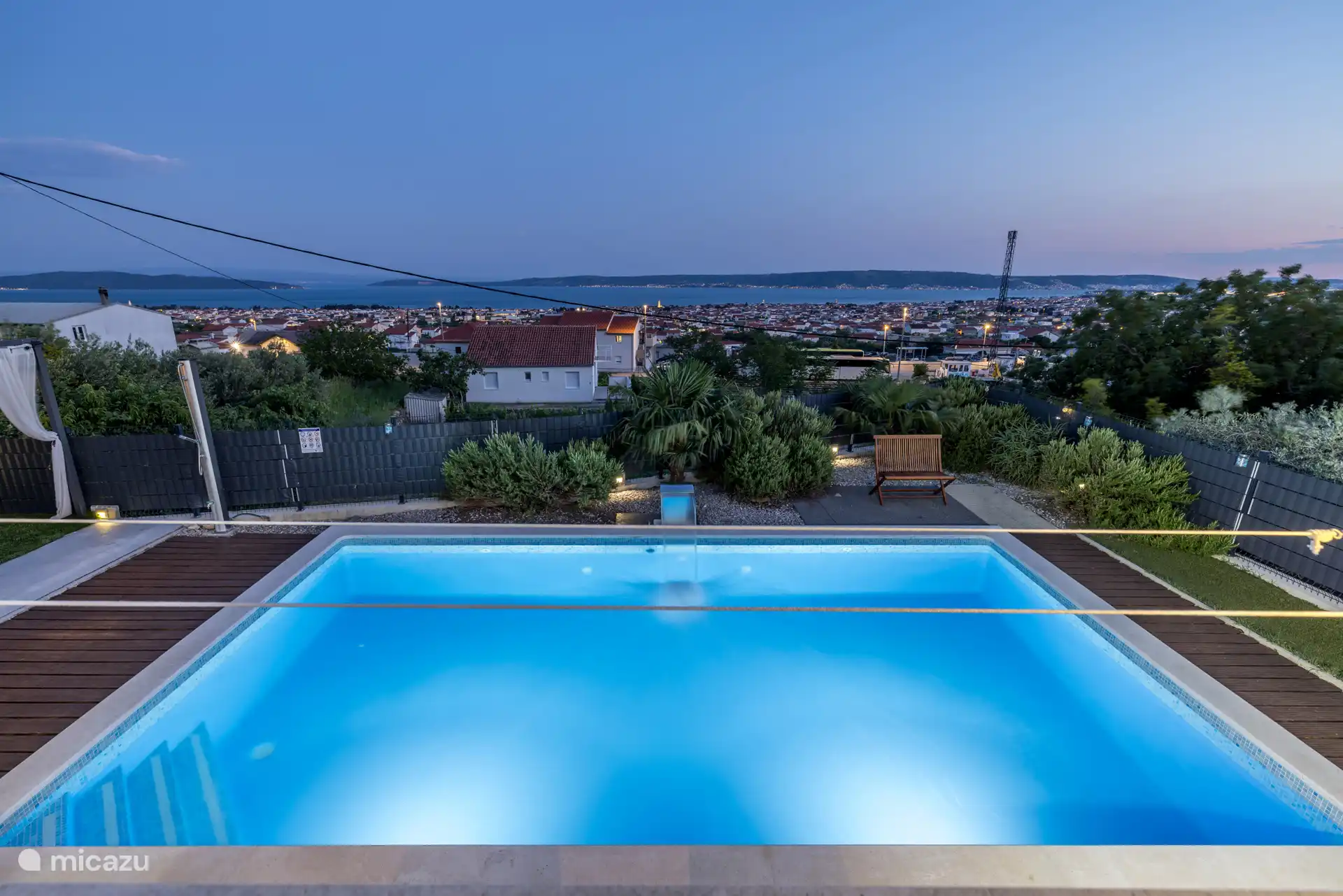 Nachts – Blick von der Terrasse auf den Pool und das Meer.