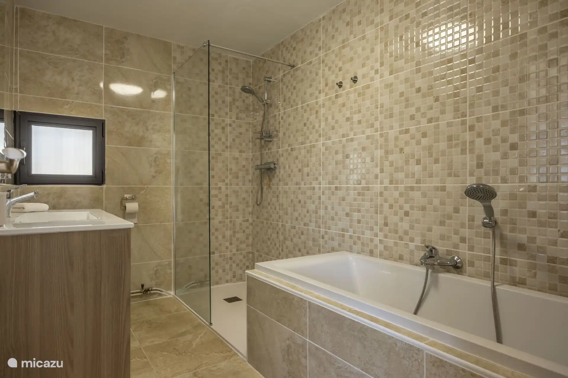 Ook vind je op deze verdieping een badkamer met bad, aparte douche, wastafel, en toilet.