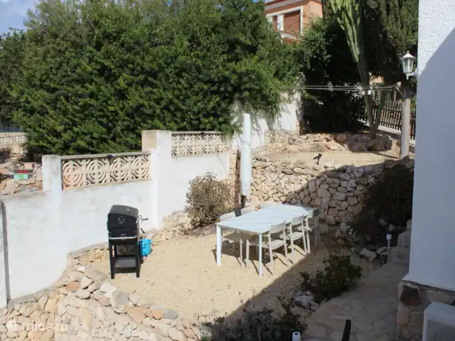 Villa Benissa Blanca | Espagne, Costa Blanca, Benissa - villa À côté de la villa, par quelques marches, se trouve une terrasse avec une grande table à manger pour 6 personnes et un barbecue sur braises.