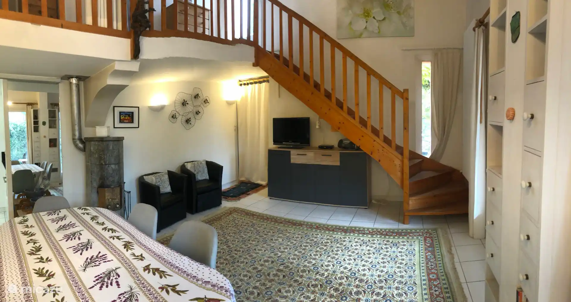 Wohnzimmer mit Specksteinofen (links) und Aufgang zum Obergeschoss und Zugang zum Solarium.