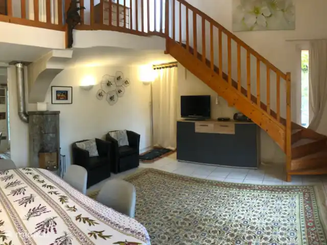 Location de Vacances France, Vaucluse, Bédoin, villa - Villa Sol Salon avec poêle en stéatite (à gauche) et escalier menant à l’étage supérieur et accès au solarium.