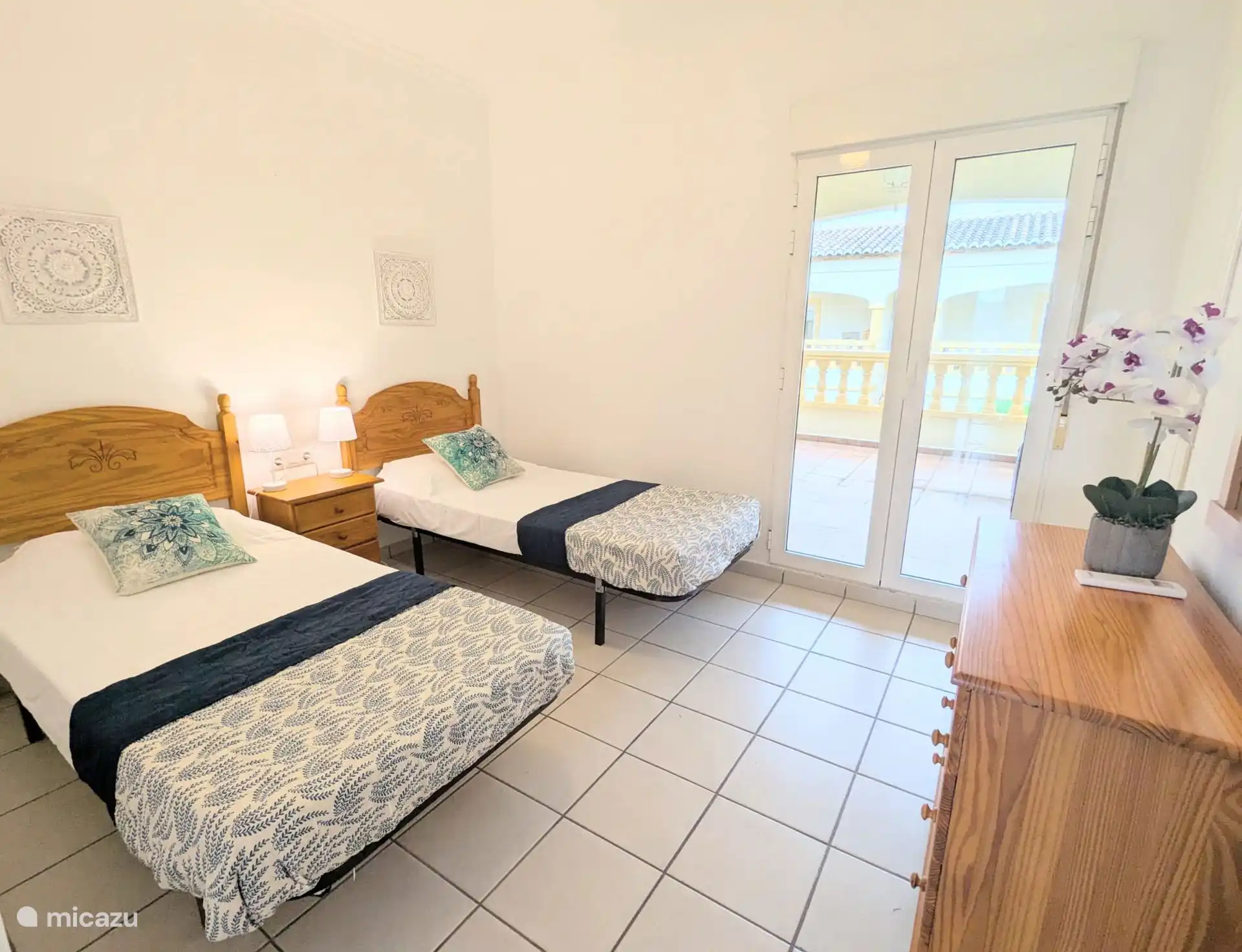Slaapkamer met 2 enkele bedden en toegang tot balkon