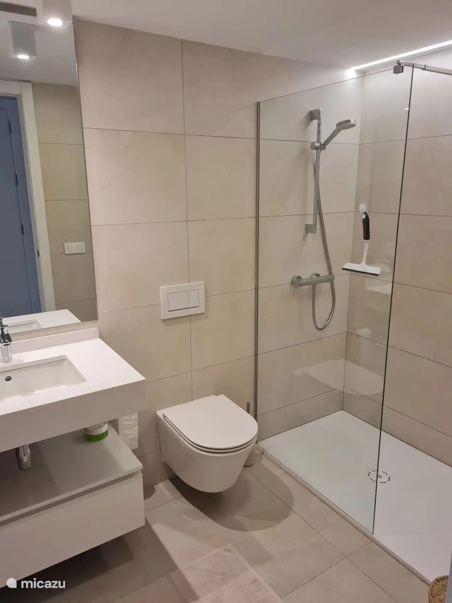 De master bedroom heeft een eigen badkamer met douche en toilet