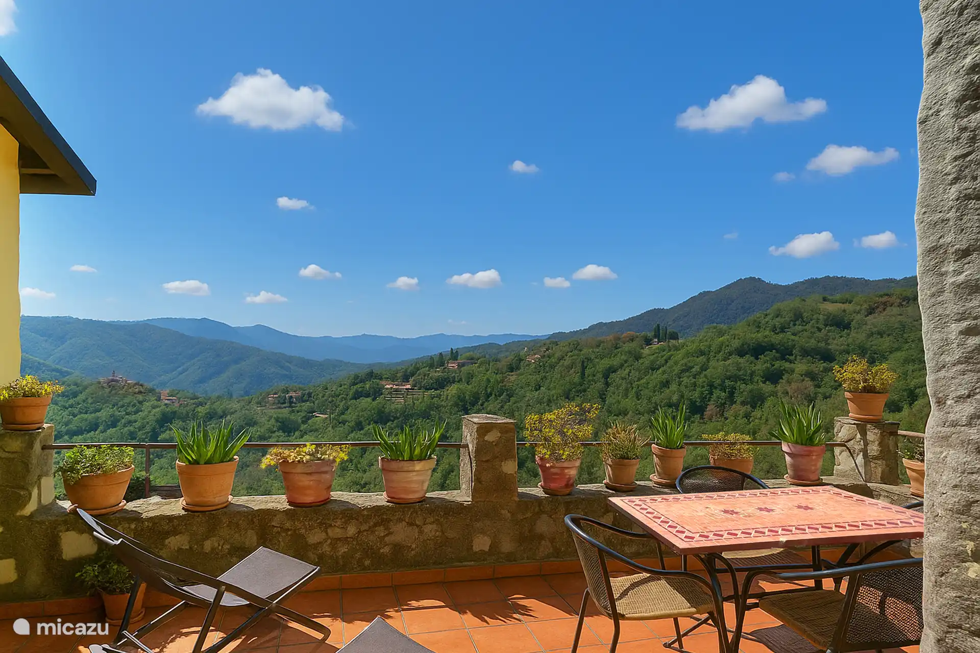 Terrasse mit Esstisch und Liegestühlen