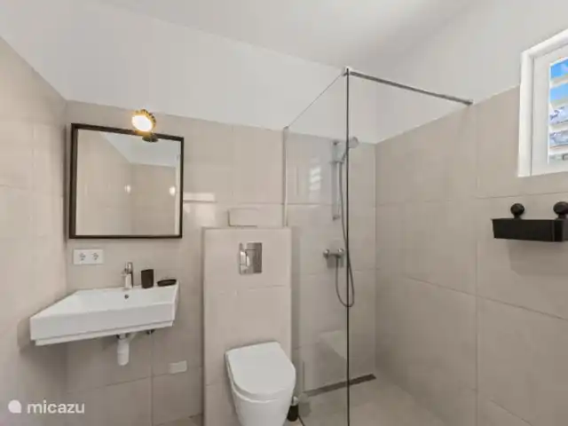 Villa Che Vita en Curazao, Bandabou (oeste), Fontein - casa vacacional El baño tiene ducha a ras de suelo, inodoro colgante y lavabo. También hay secador de pelo.