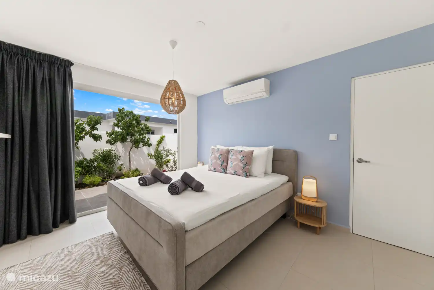 Hauptschlafzimmer mit Schiebetüren zur Terrasse, mit Sitzgelegenheiten.