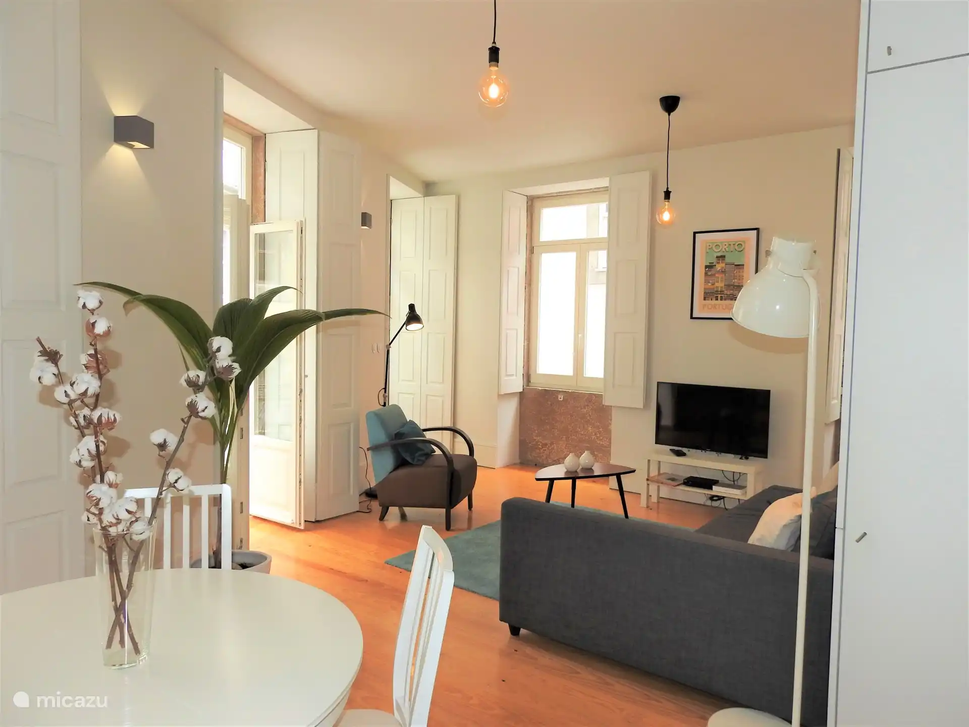 Wohnzimmer mit Zugang zum Balkon und Smart-TV