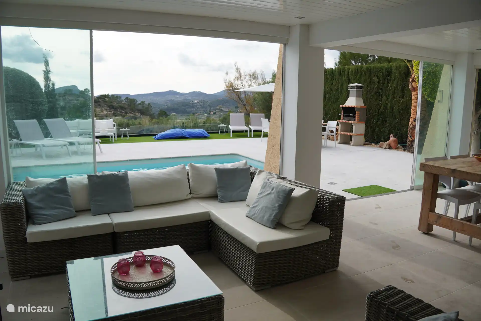 Drinnen sitzt du bequem im Wohnzimmerbereich und blickst frei durch die verschiebbaren Fenster, die sich öffnen und schließen lassen. Du hast immer das Gefühl, draußen zu sein.