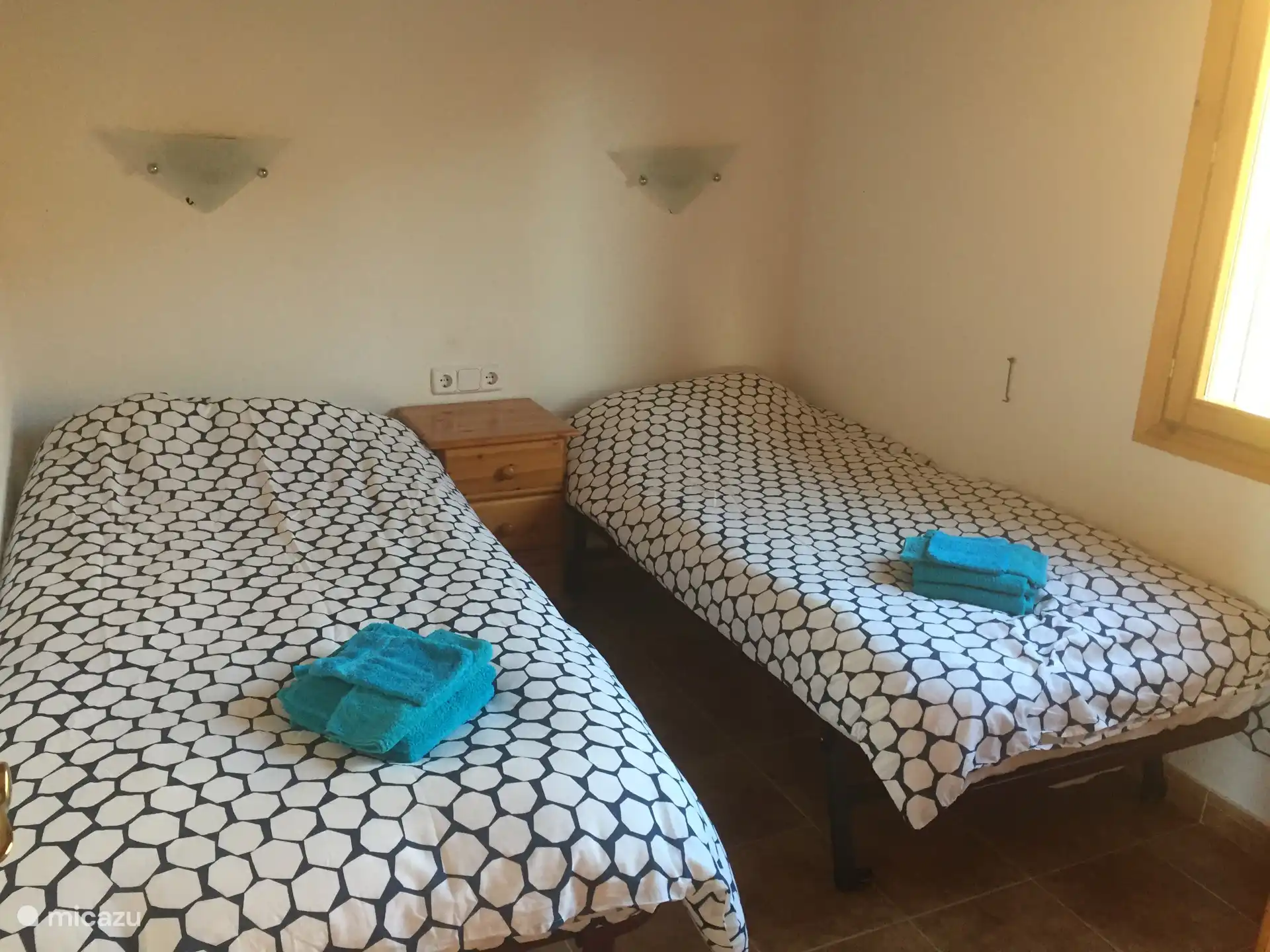 Das vierte Schlafzimmer im Obergeschoss verfügt über zwei Einzelbetten, einen Nachttisch und einen geräumigen Kleiderschrank. Dieser Raum ist außerdem mit Deckenventilator und Klimaanlage ausgestattet. 