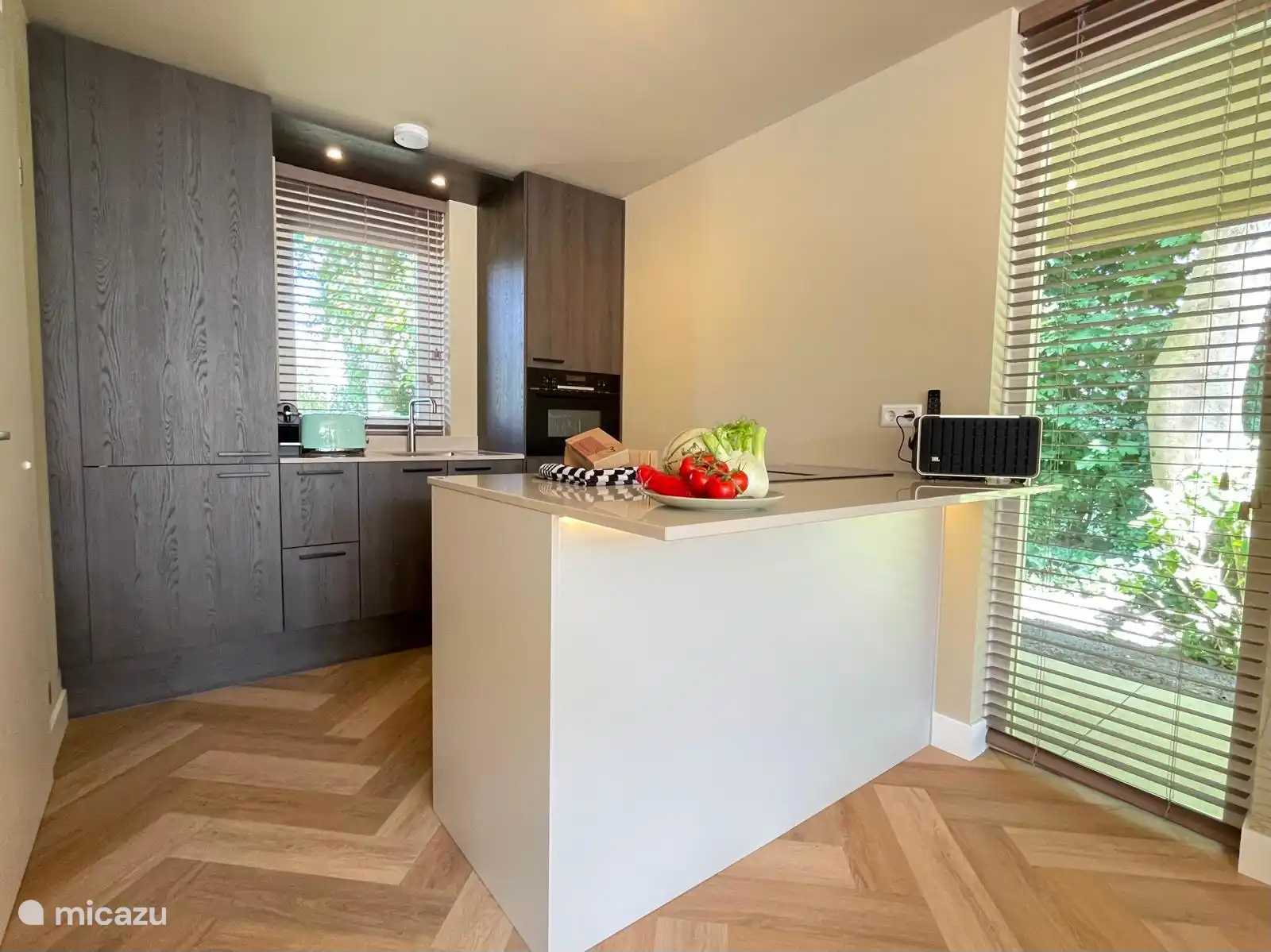 Moderne Küche mit Kombi-Mikrowelle, Quooker, Herd mit Bora, Nespresso, Kühlschrank mit Gefrierfach und Geschirrspüler.