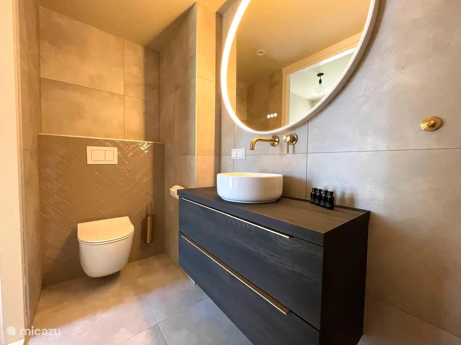 Luxuriöses Badezimmer im Erdgeschoss mit Regendusche, Waschbecken und WC. Im ersten Stock befindet sich eine separate Toilette.