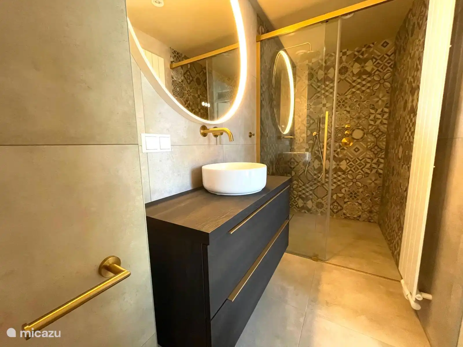 Luxuriöses Badezimmer im Erdgeschoss mit Regendusche, Waschbecken und WC. Im ersten Stock befindet sich eine separate Toilette.