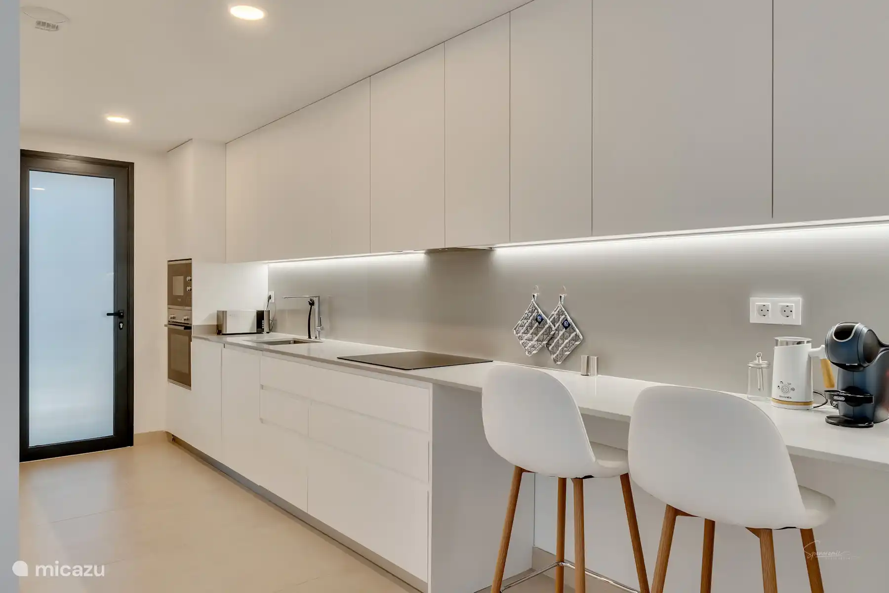 Moderne Küche mit Mikrowelle, Backofen, Induktionskochfeld, Kaffeemaschine Dolce Gusto, Wasserkocher, Milchaufschäumer usw