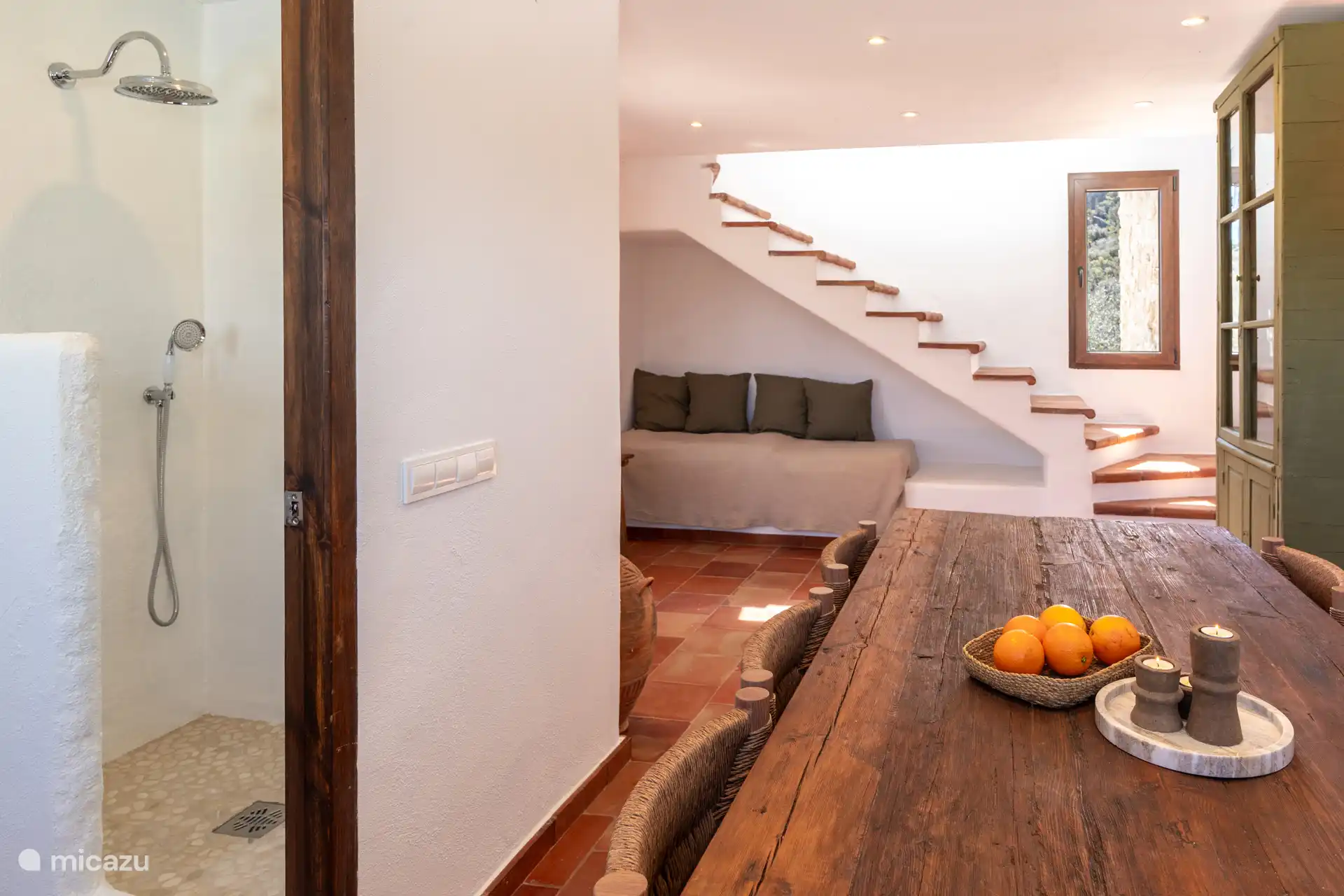 Warme sfeer in de woonkamer op de begane grond met bank, trap en badkamer in de buurt