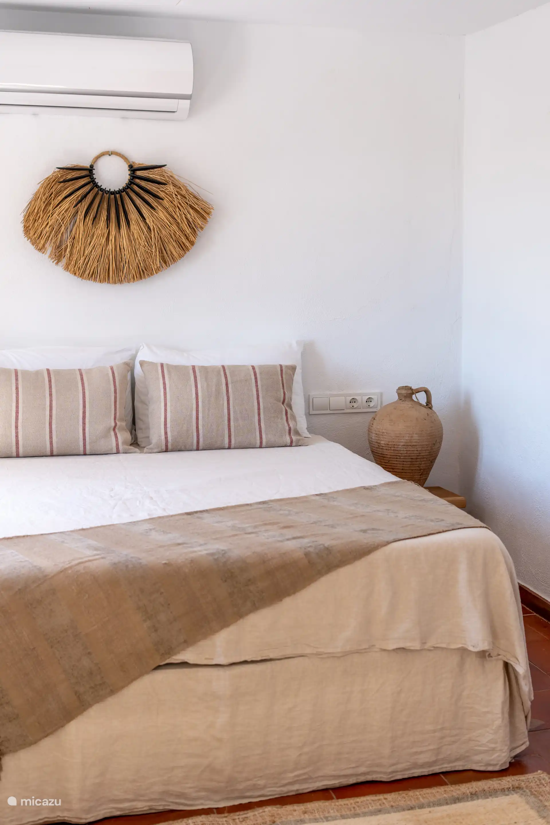 Lichte kamer met tweepersoonsbed en uitzicht op de opkomende zon