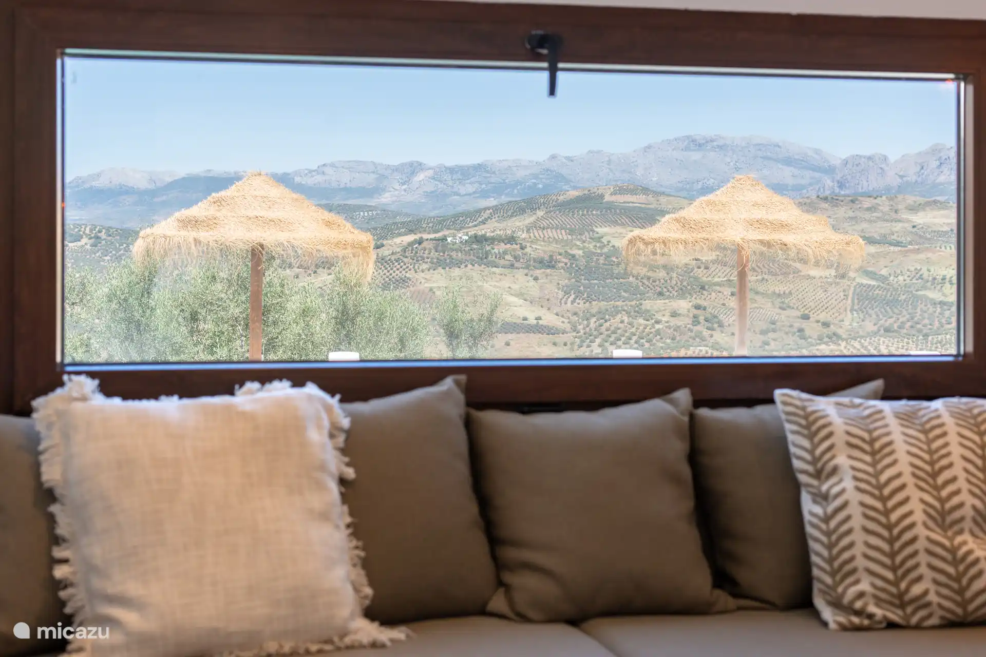 Gezellige slaapbank met uitzicht op het zwembad en de bergen, perfect om te loungen of te genieten van een goed boek.