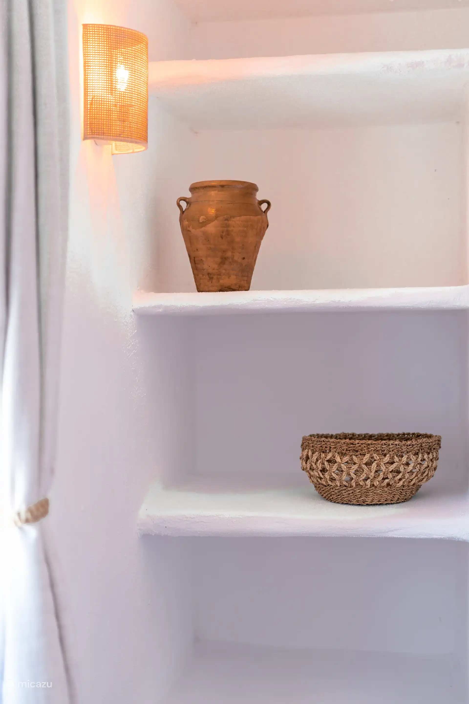 Ingebouwde plank met een oude aarden pot die werd gebruikt om vlees in olie te bewaren