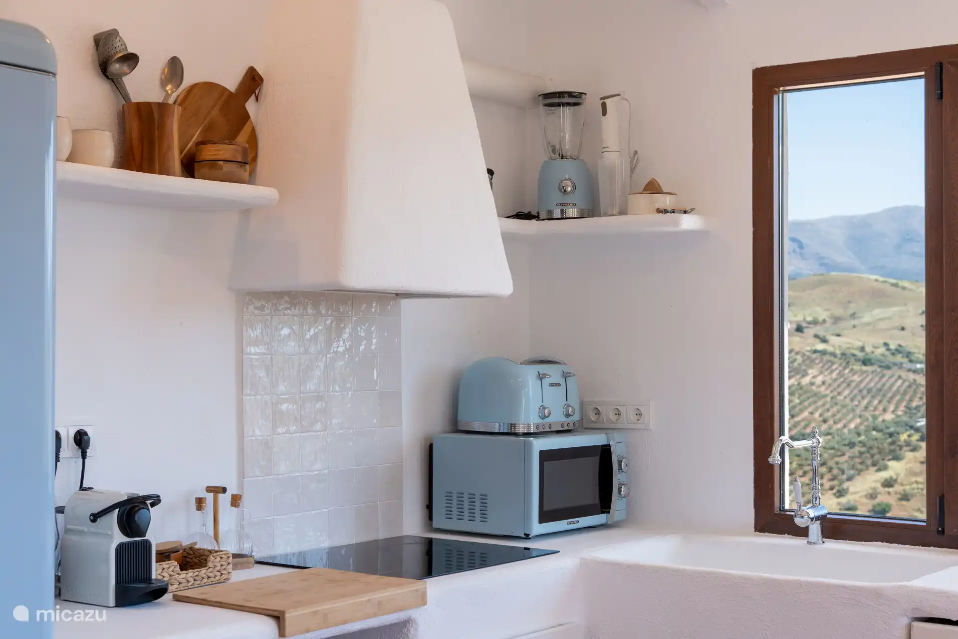 Keuken met een Andalusische uitstraling: ingebouwde meubels en stoffen gordijnen die traditie en landelijke eenvoud oproepen