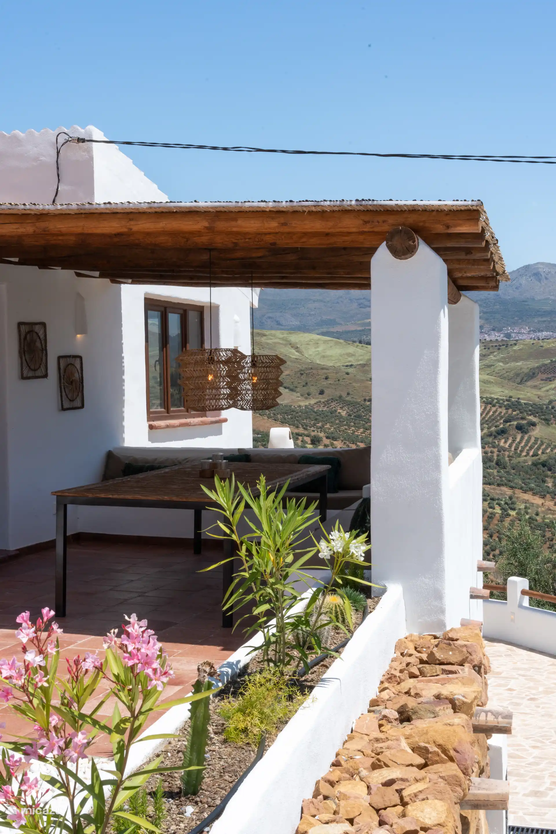 Charmante rieten pergola die een tafel beschermt voor ontbijt en lunch met uitzicht.