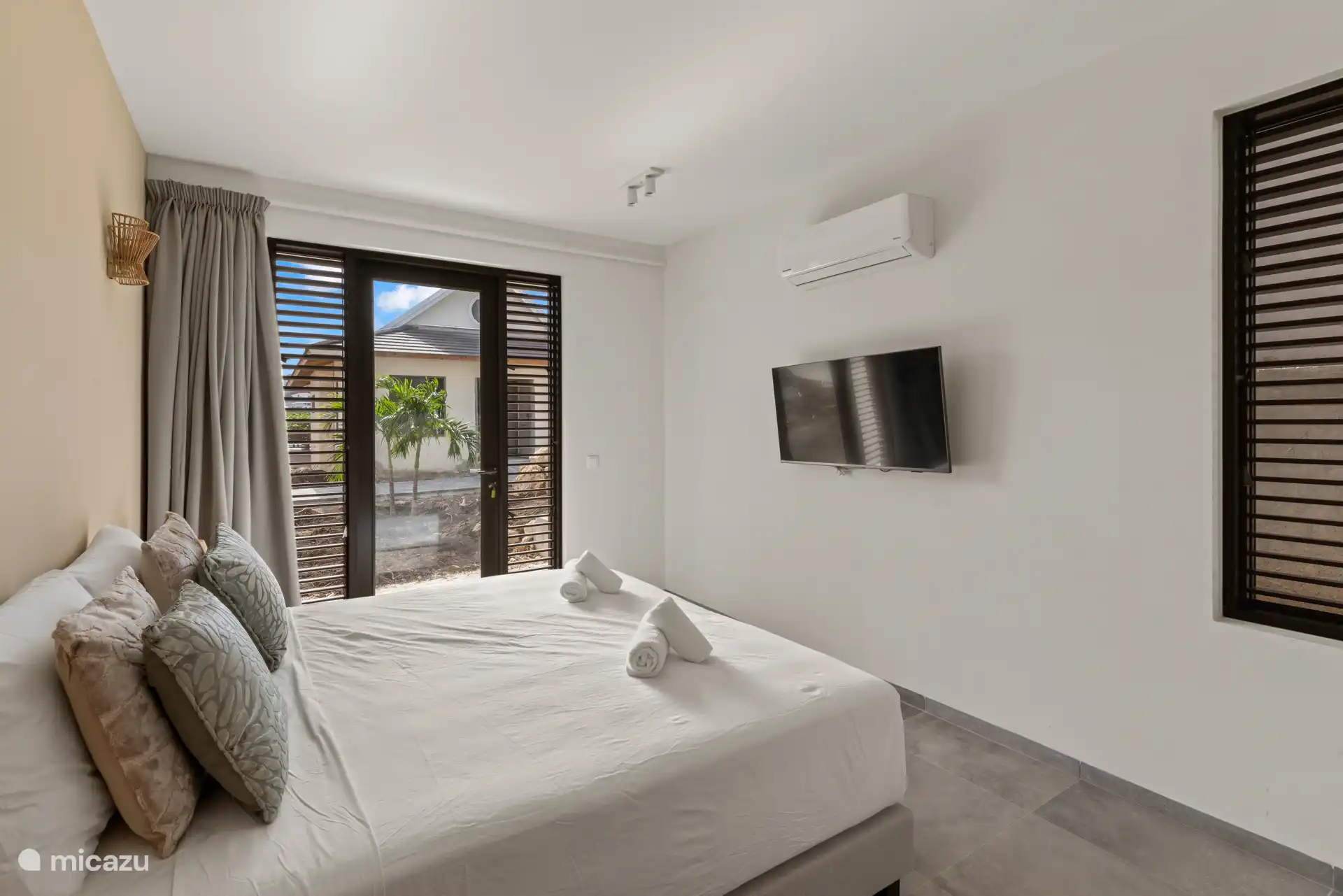 Schlafzimmer 4, Treppe hinunter, mit Doppelbett, eigenem Bad, TV, Kleiderschrank und Klimaanlage.