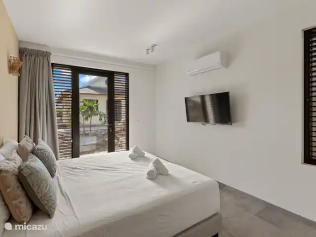 Villa Jazmyn 31 Blue Bay Resort | Curaçao, Curaçao-Centre, Blue Bay - villa Chambre 4, escalier en bas, avec lit double, salle de bain privée, TV, armoire et climatisation.