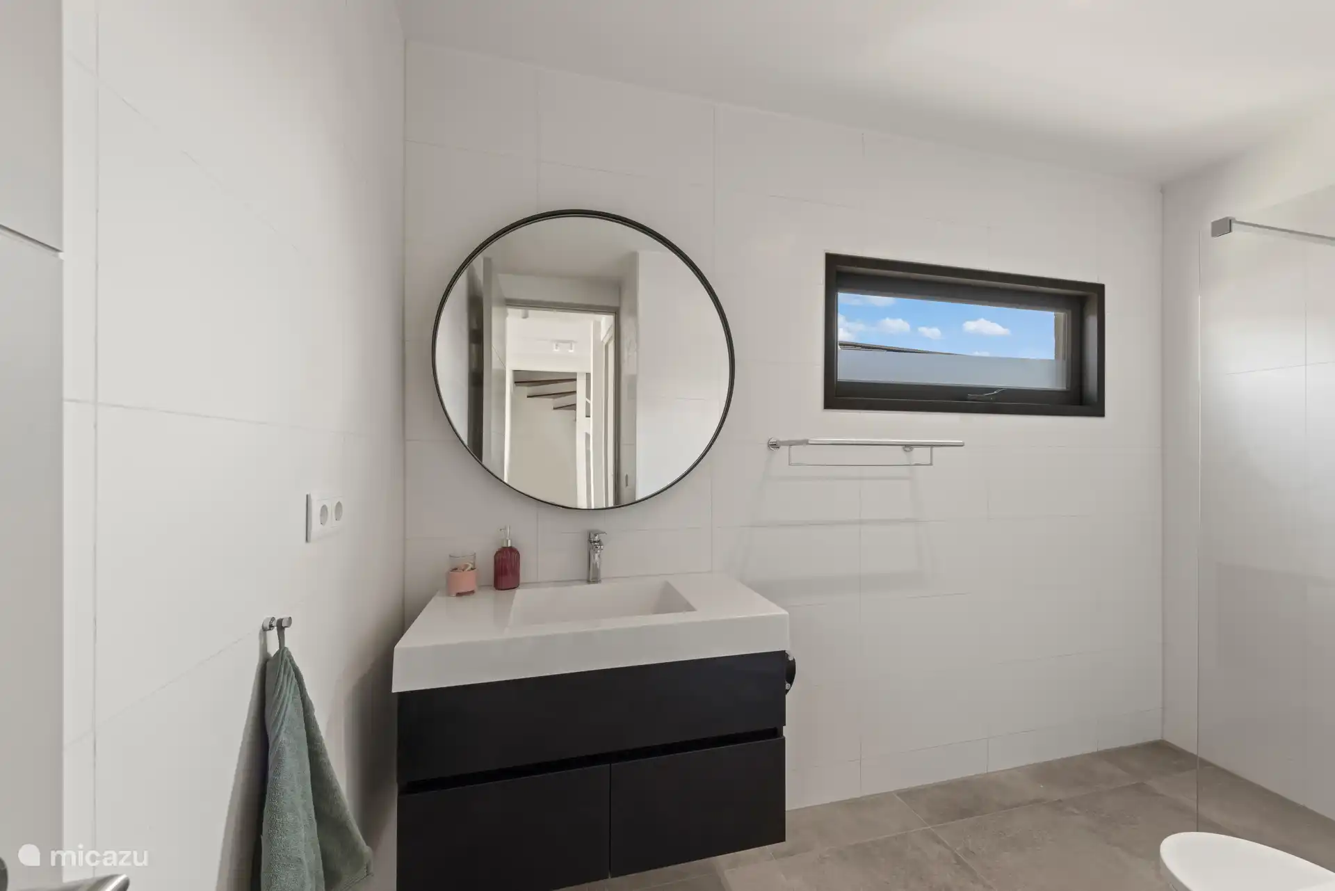 Schönes Badezimmer mit Regendusche, WC und geräumigem Waschbecken