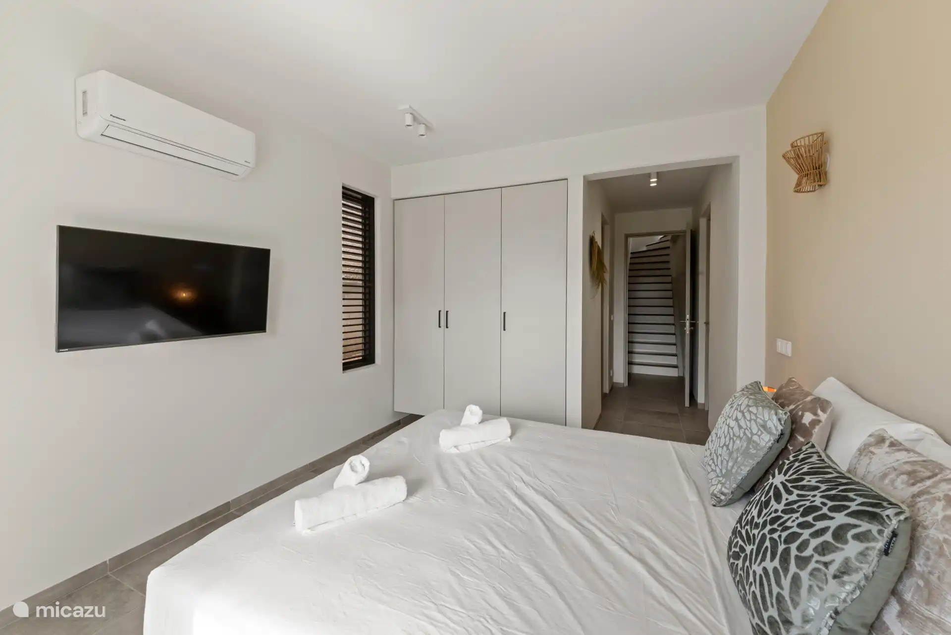 Schlafzimmer 4, Treppe hinunter, mit Doppelbett, eigenem Bad, TV, Kleiderschrank und Klimaanlage.