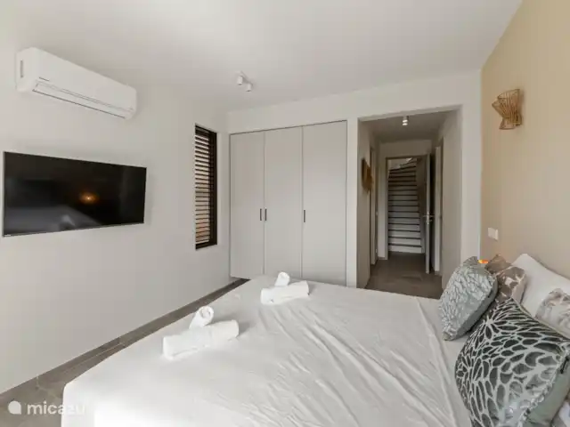 Villa Jazmyn 31 Blue Bay Resort | Curaçao, Curaçao-Centre, Blue Bay - villa Chambre 4, escalier en bas, avec lit double, salle de bain privée, TV, armoire et climatisation.