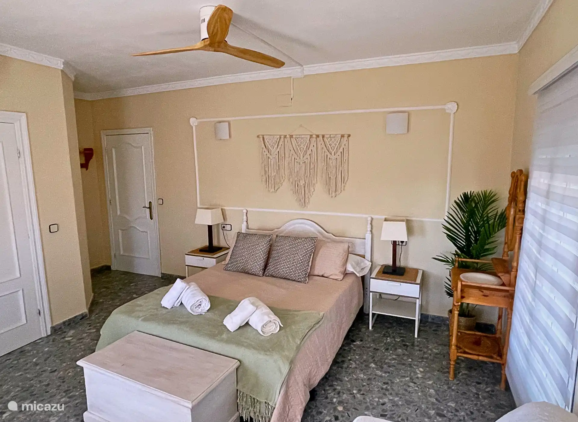 Dormitorio 1, con armario grande, aire acindicionado, ventilador, TV, caja fuerte y un sofa cama pequeño.