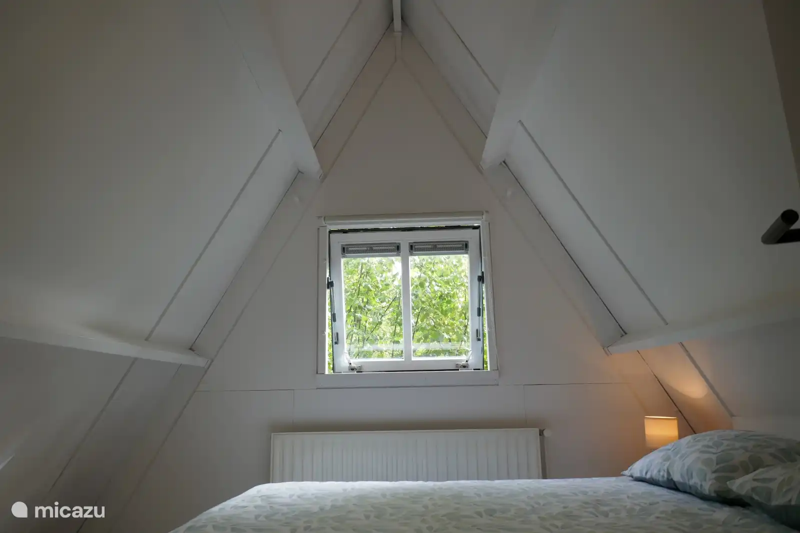 Gemütliches Zimmer mit bequemem Bett und warmer Beleuchtung. Minimalistisch und beruhigend, ideal für zwei Personen.