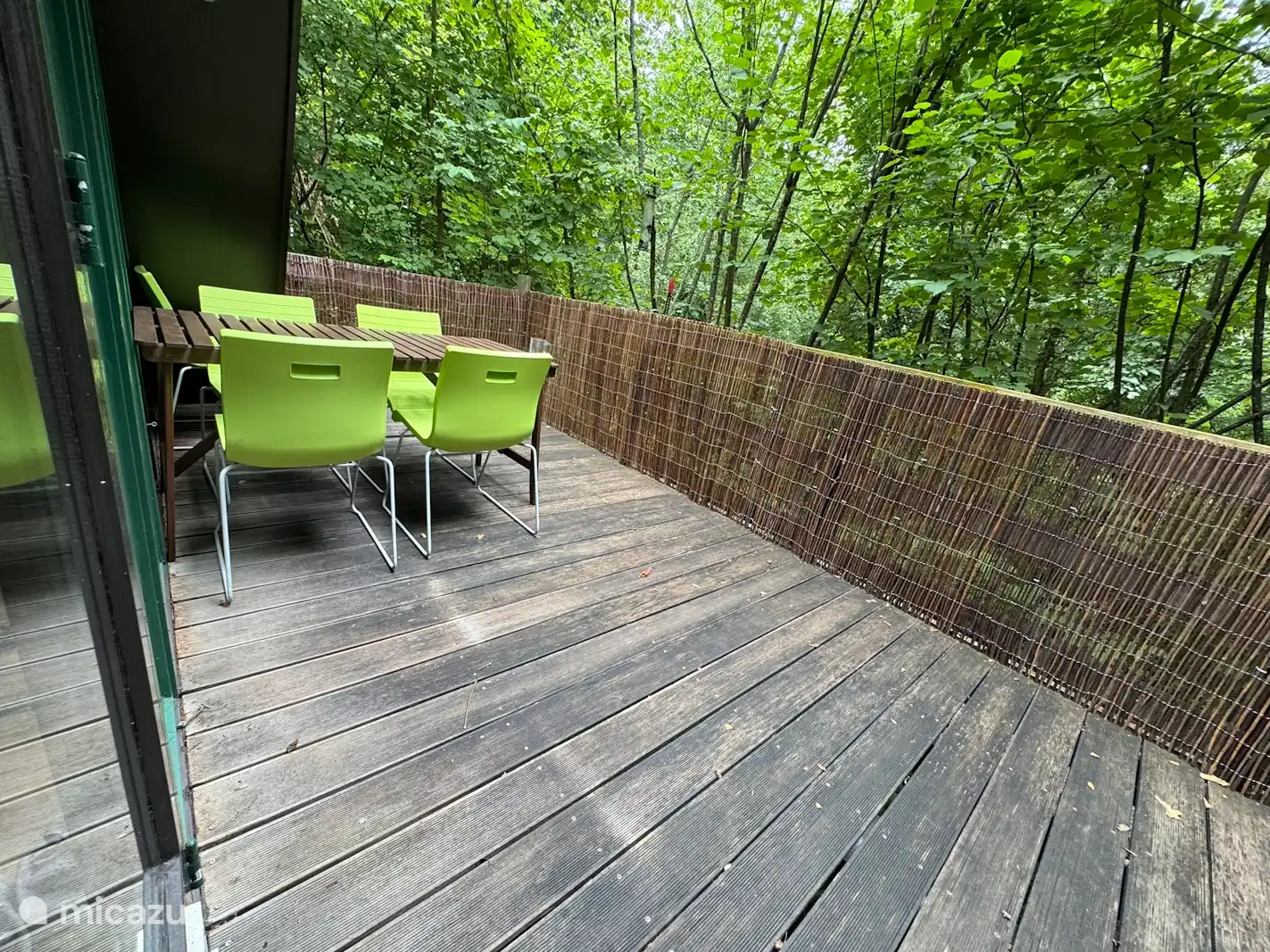 Stilvolle Holzterrasse mitten im Grünen. Genießen Sie das Leben im Freien mit modernen Sitzgelegenheiten und Privatsphäre.