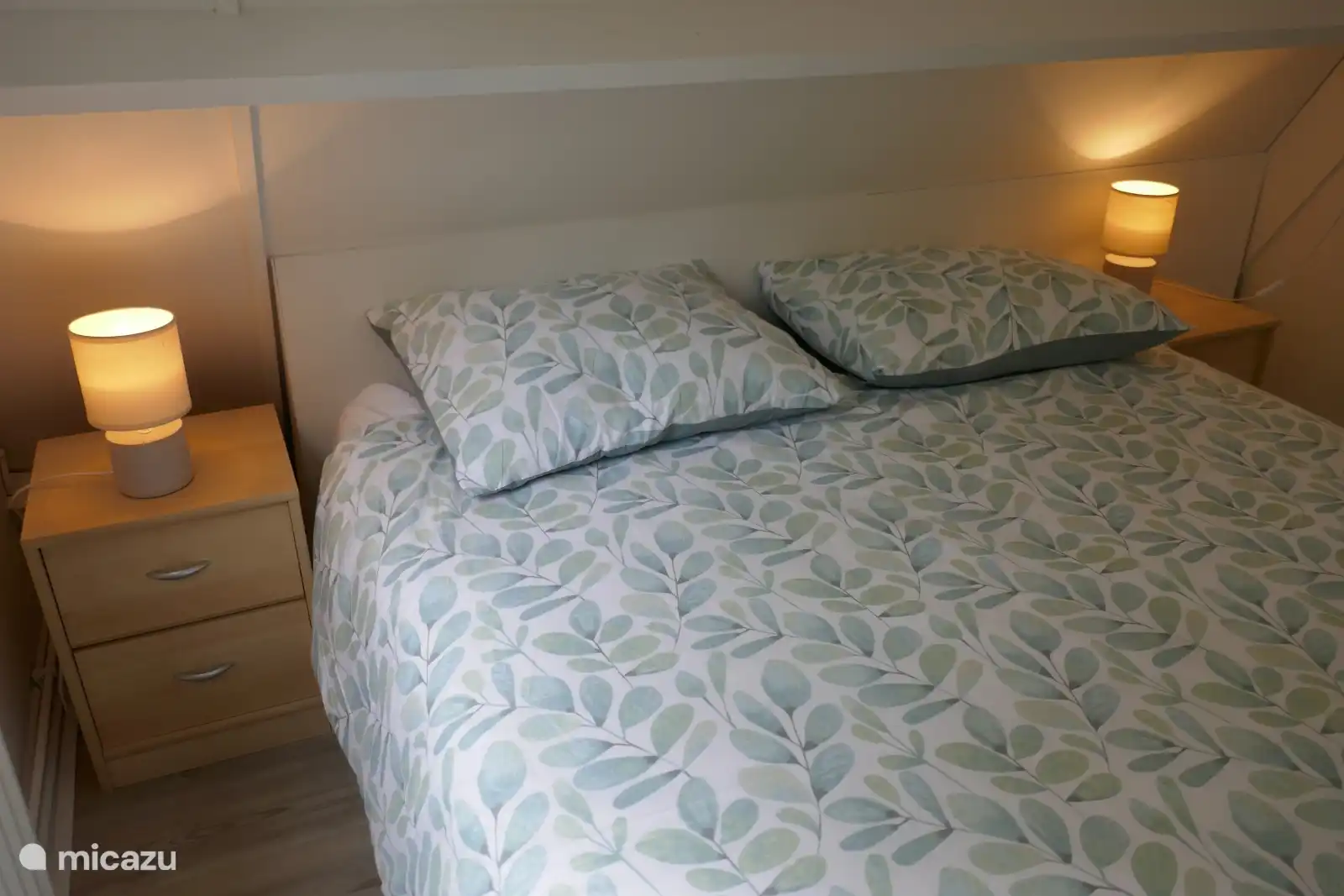 Gemütliches Zimmer mit bequemem Bett und warmer Beleuchtung. Minimalistisch und beruhigend, ideal für zwei Personen.