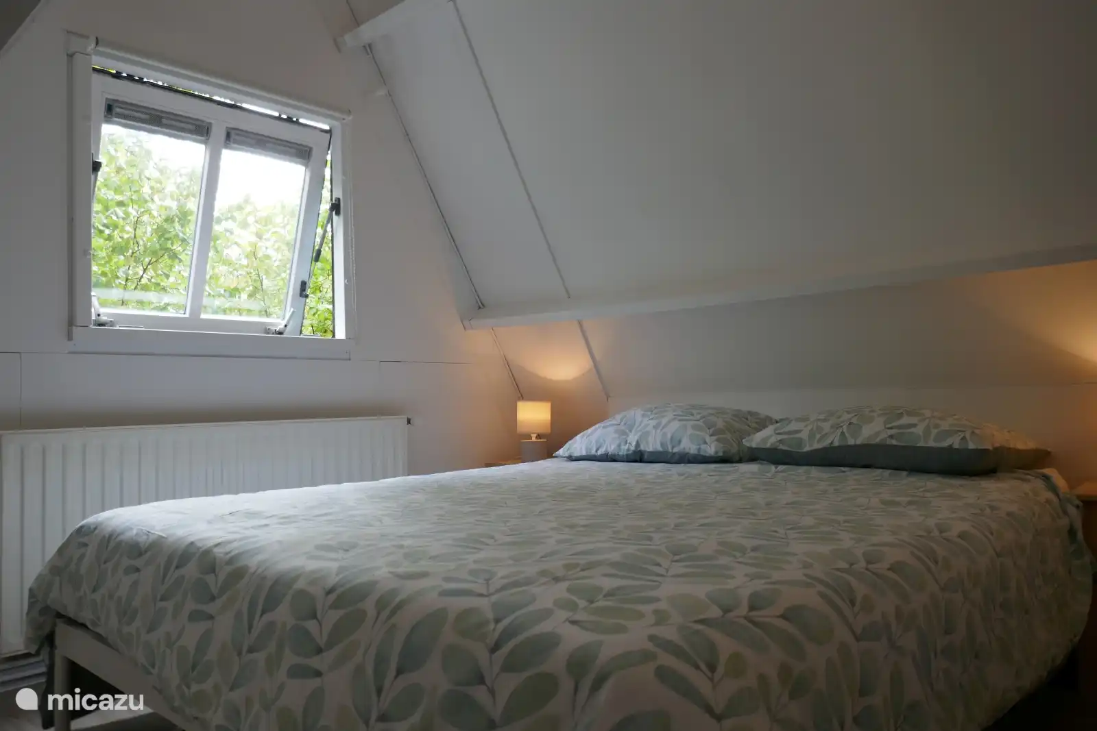 Gemütliches Zimmer mit bequemem Bett und warmer Beleuchtung. Minimalistisch und beruhigend, ideal für zwei Personen.