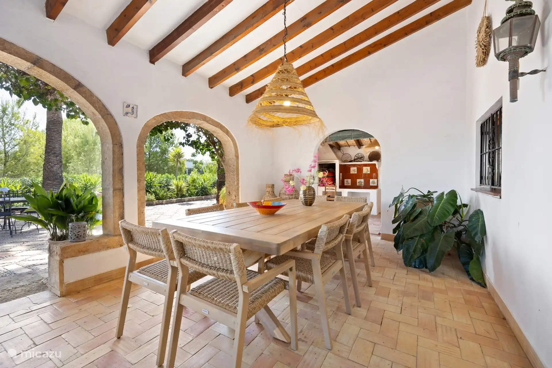 Un joli naya à l’avant de la finca, meublé d’un fauteuil confortable pour quatre personnes et d’une grande table à manger avec dix chaises. 