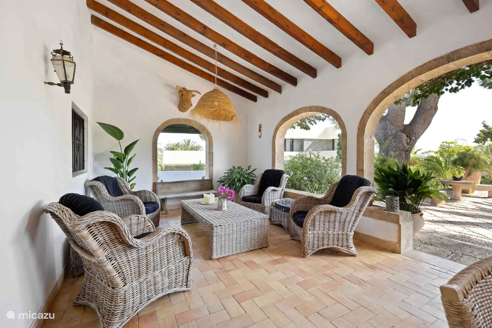 Un joli naya à l’avant de la finca, meublé d’un fauteuil confortable pour quatre personnes et d’une grande table à manger avec dix chaises. 