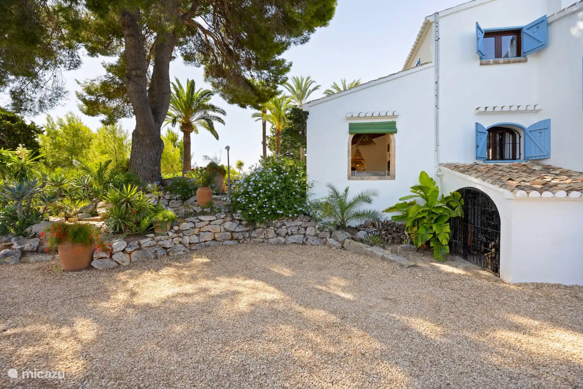 Côté de la finca avec un jardin méditerranéen, où vous pouvez aussi garer votre voiture. Au total, il y a de la place pour trois voitures sur place.