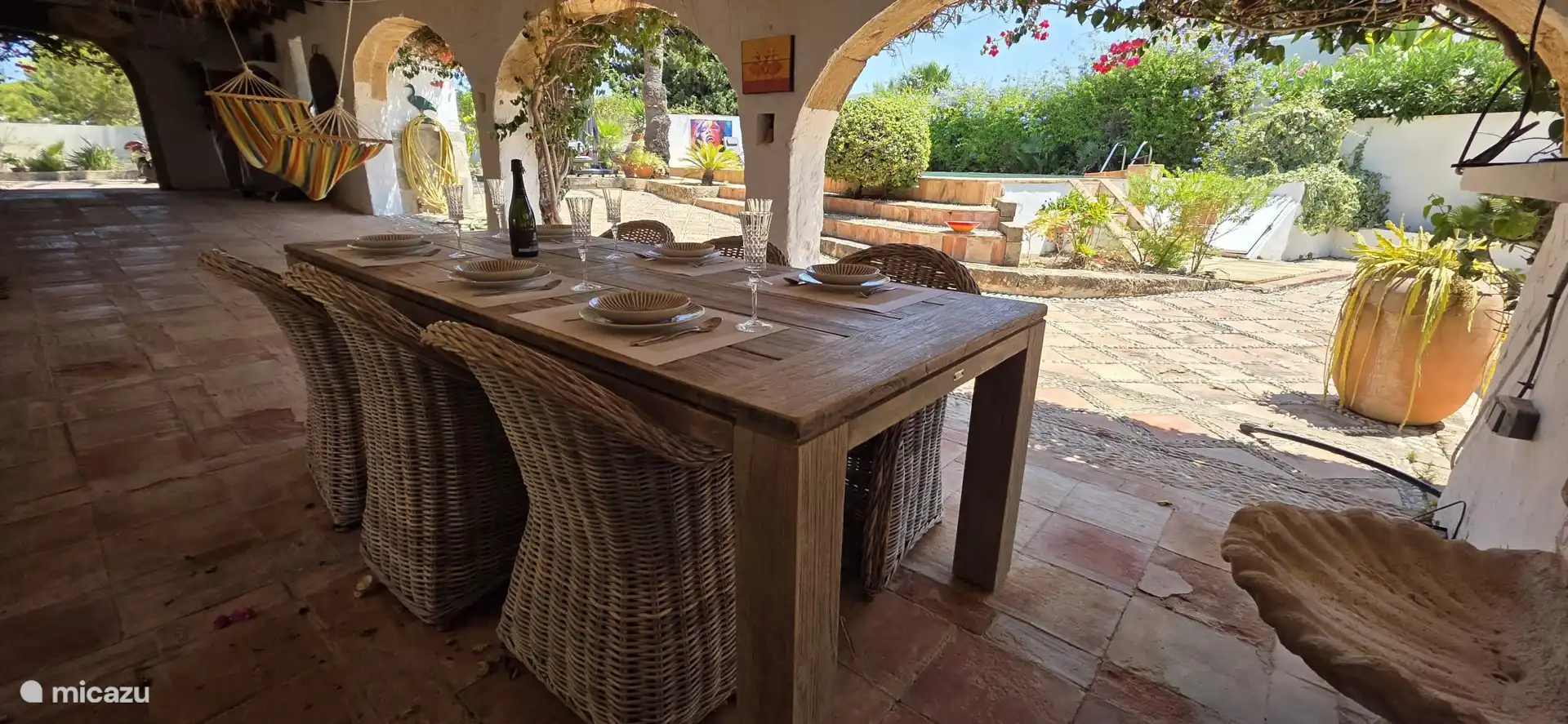 Dining table in the side naya with a view of the lovely swimming pool