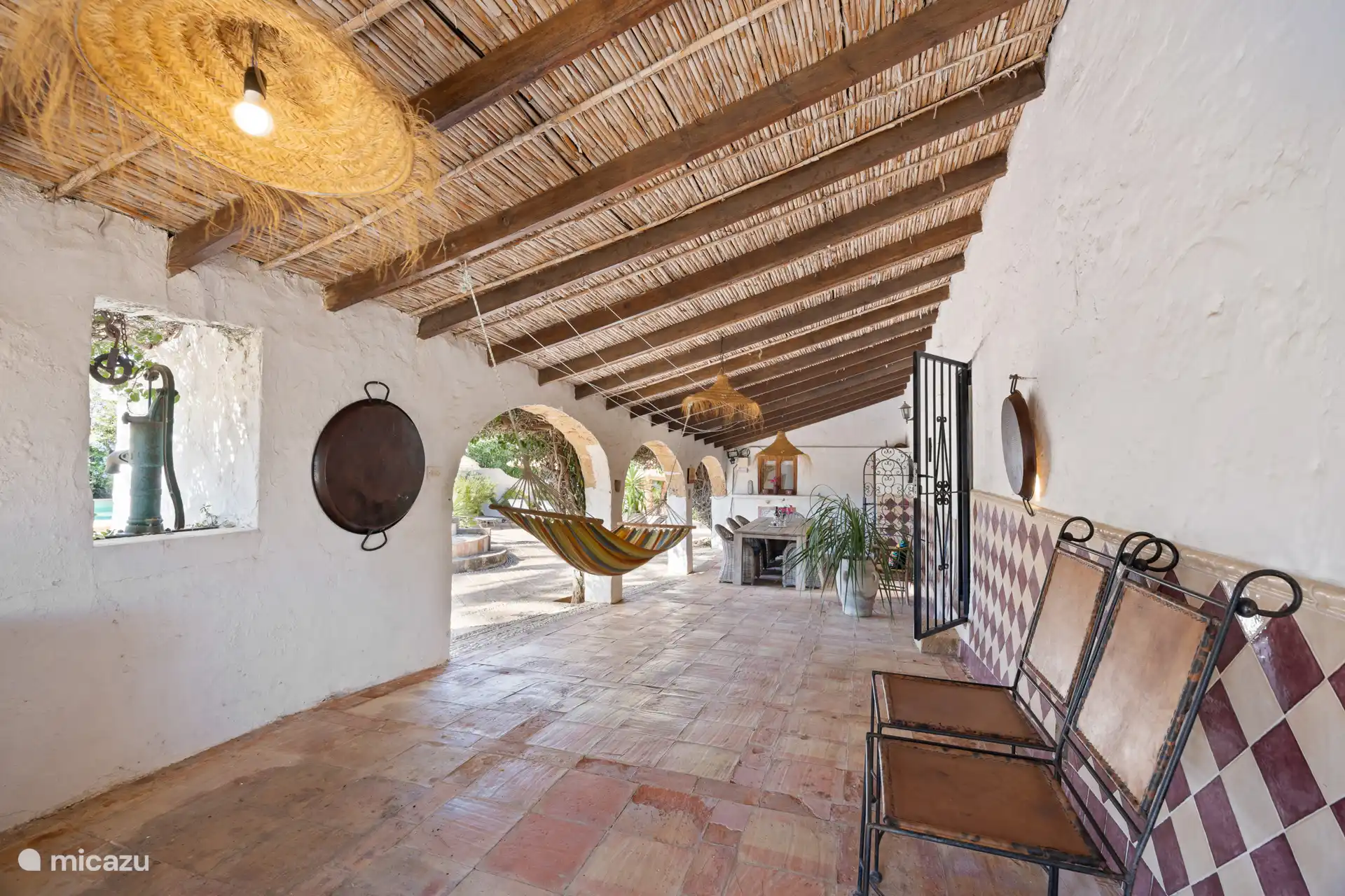 Naya sur le côté de la Finca avec une grande table à manger, un hamac et un kamado. 