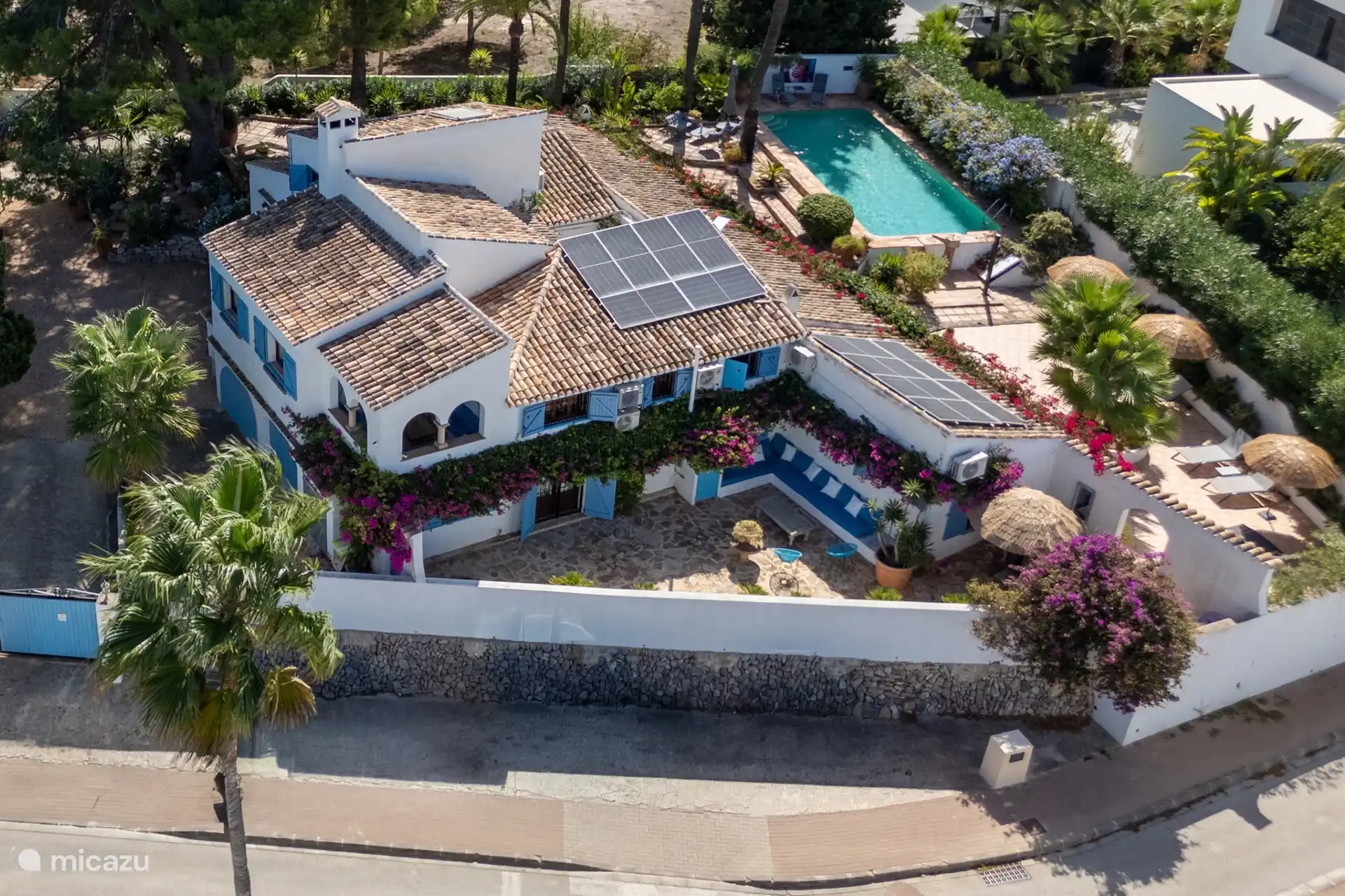 Vue aérienne de la Finca La Perla, située sur un terrain de 1 200 m² dans un quartier résidentiel paisible. La propriété de 330 m² dégage un charme espagnol authentique et se trouve à seulement 1,4 km de la plage d’Arenal.