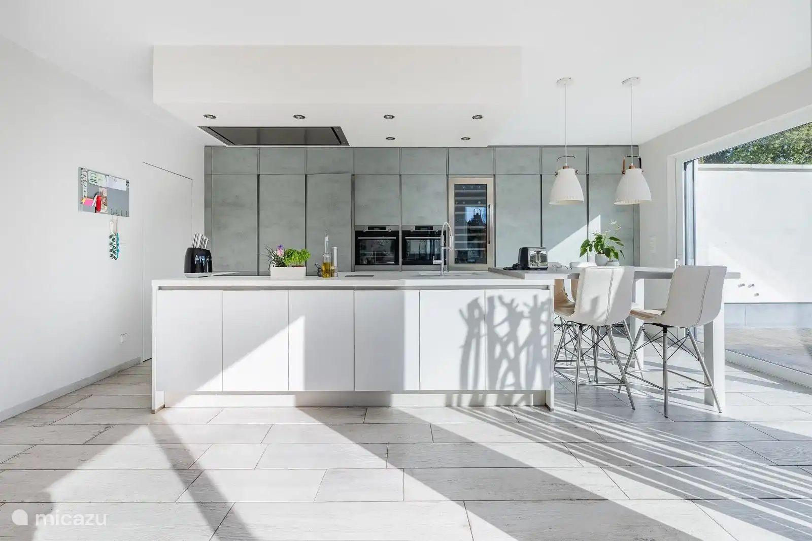 Moderna cocina abierta hiperequipada con gran isla de cocción (4 m) y mesa de comedor alta para 4 personas. Placa de inducción con 6 zonas, lavavajillas XL, microondas combi, horno, congelador, nevera, vinoteca. Desde la cocina se puede acceder directamente a la mesa de comedor y a las vistas al jardín, las terrazas y la piscina. Salvamento