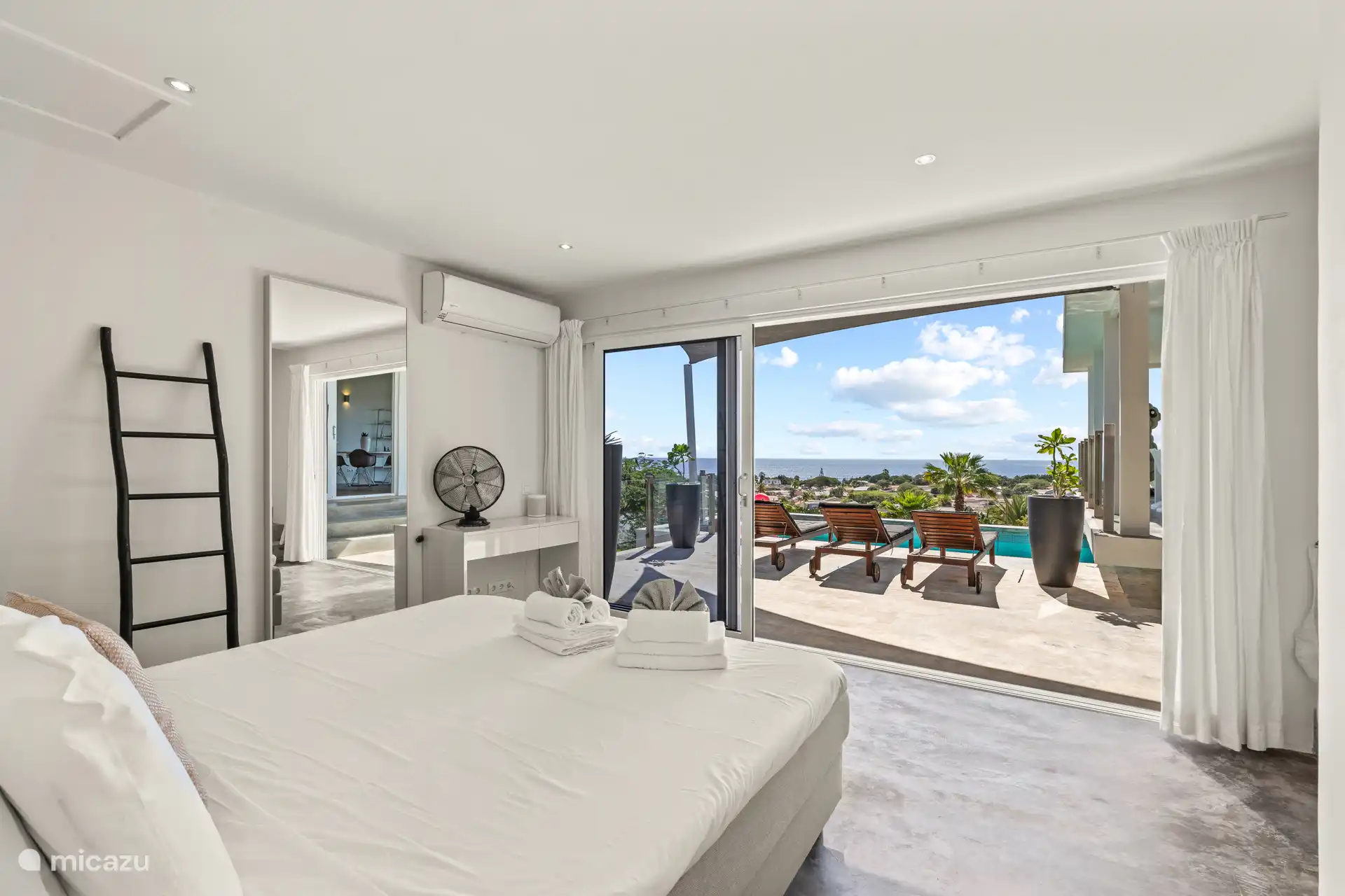 The master bedroom has large sliding doors to the pool deck.