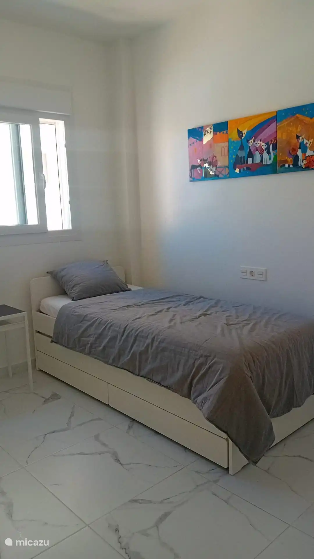 Eenpersoonbed met een tweede bed dat eronder geschoven is wanneer dit niet gebruikt wordt