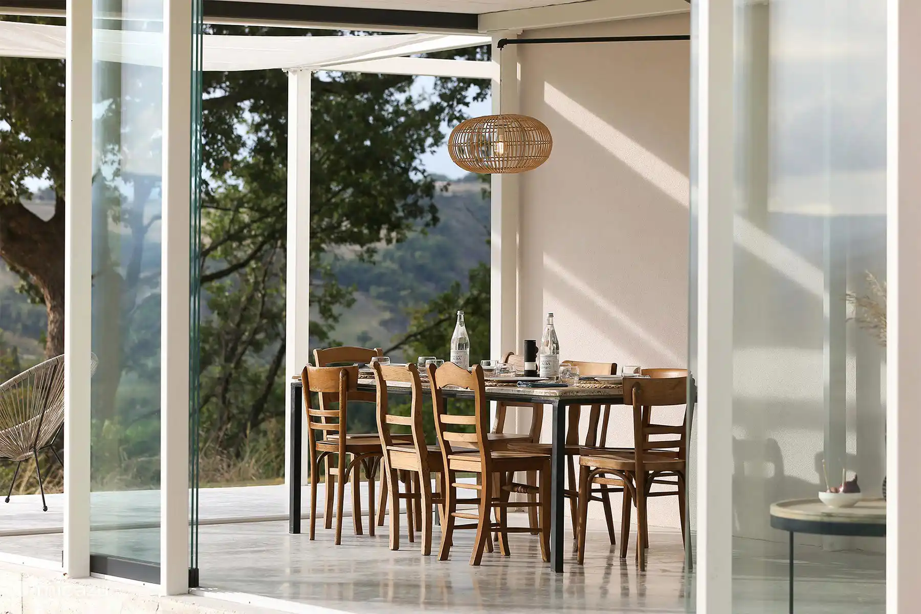 Ein rustikal-schicker Außen-Esstisch für gemeinsame Mahlzeiten gedeckt und bietet einen atemberaubenden Panoramablick auf die Hügel.