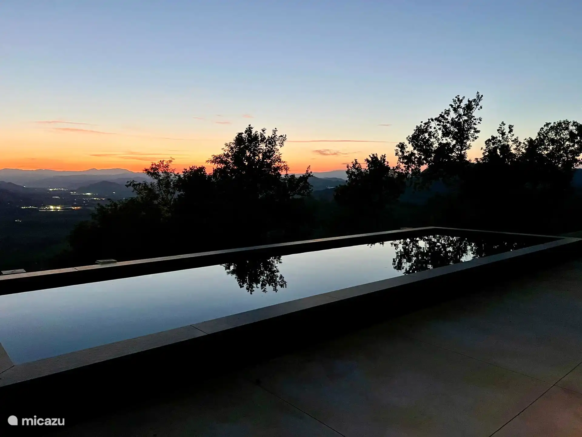 Modern rechthoekig zwart bassin met een panoramisch zonneterras met uitzicht op de heuvels, met spectaculaire uitzichten op de Apennijnen.