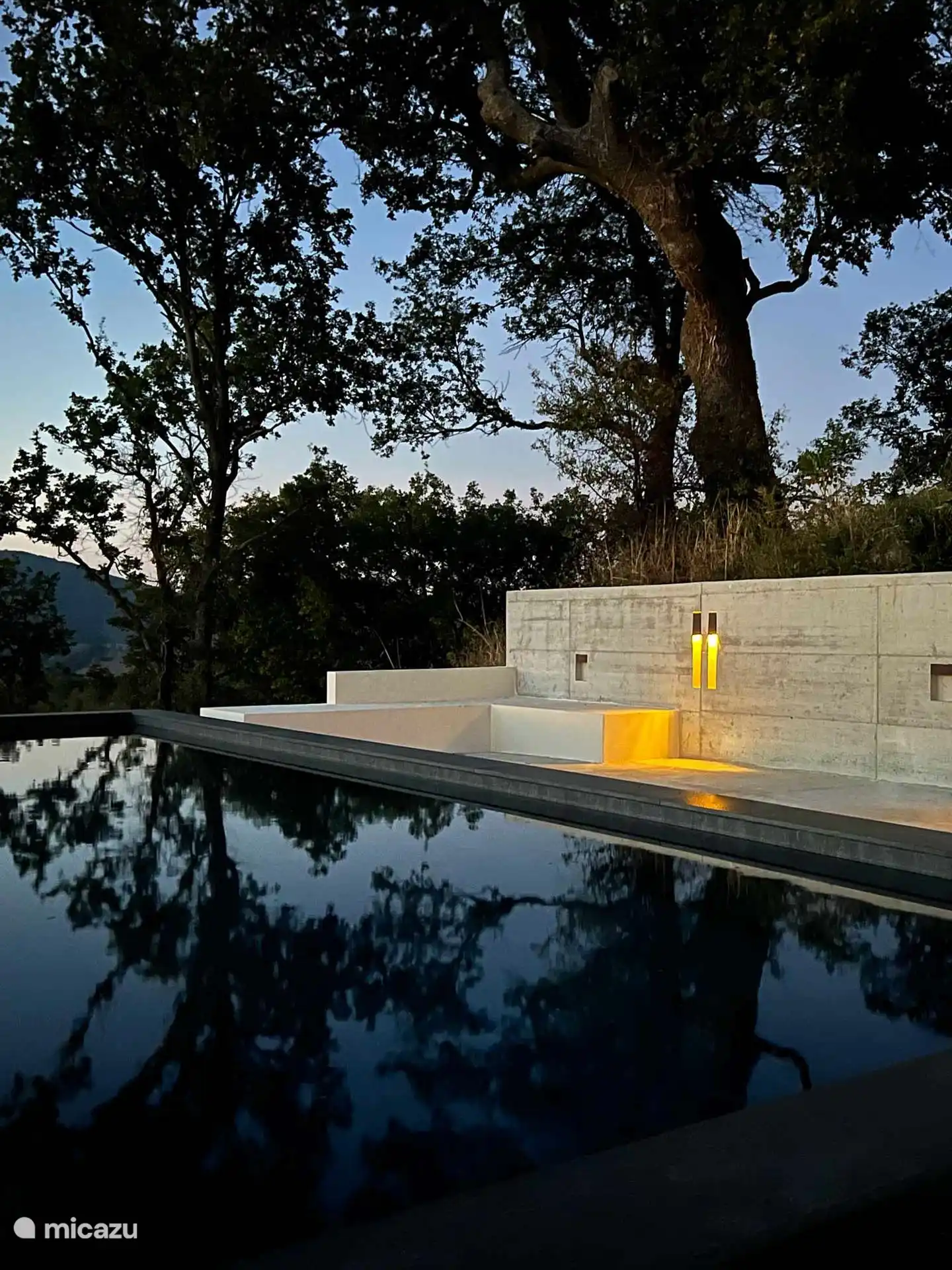 Modern rechthoekig zwart bassin met een panoramisch zonneterras met uitzicht op de heuvels, met spectaculaire uitzichten op de Apennijnen.