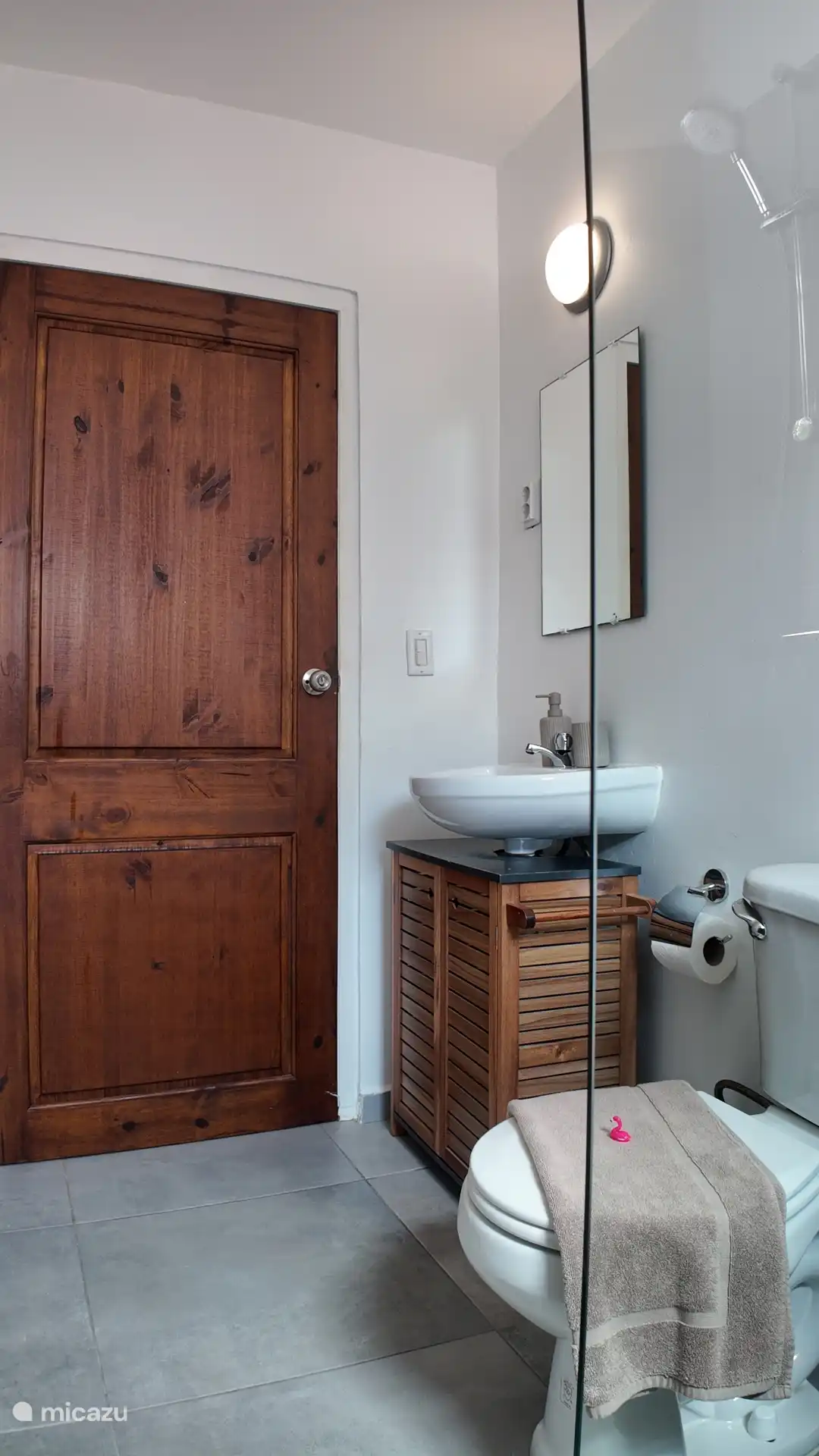 Badezimmer mit WC, Badmöbeln und Dusche.