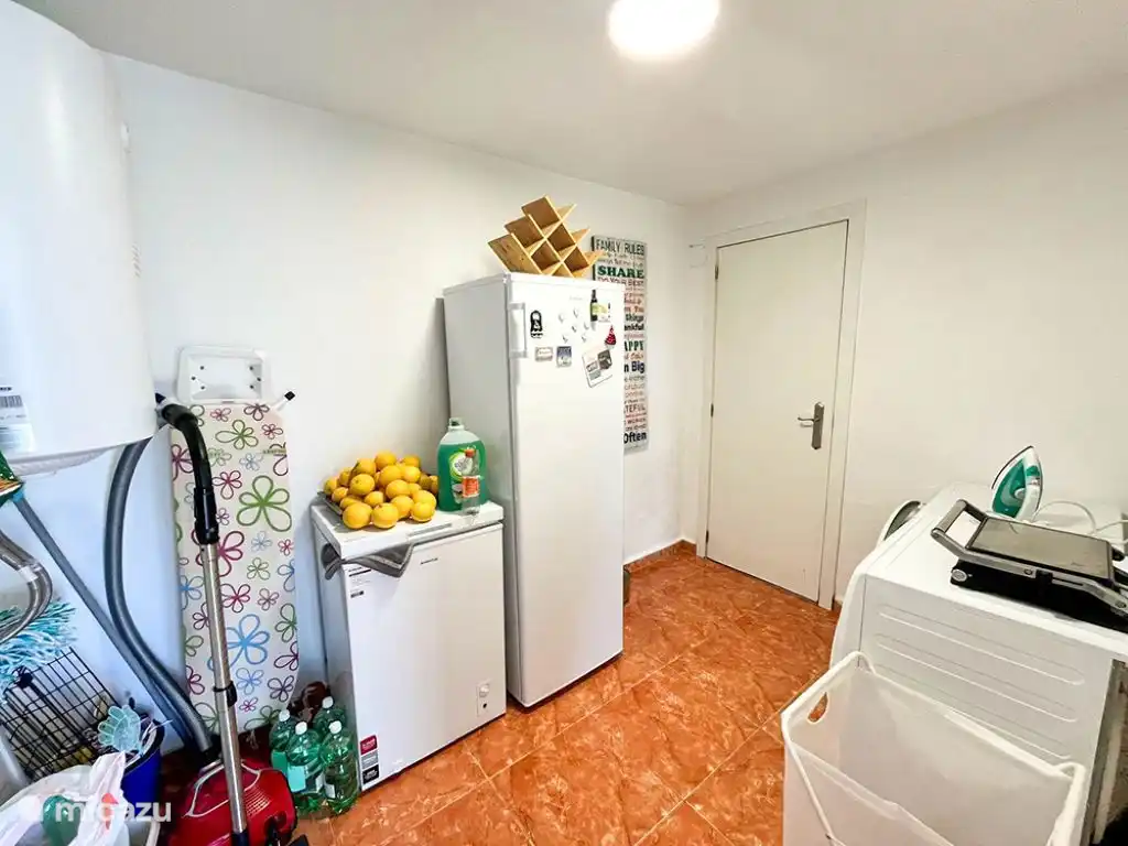 Sala de servicio con nevera grande, congelador
lavadora, secadora y aspiradora