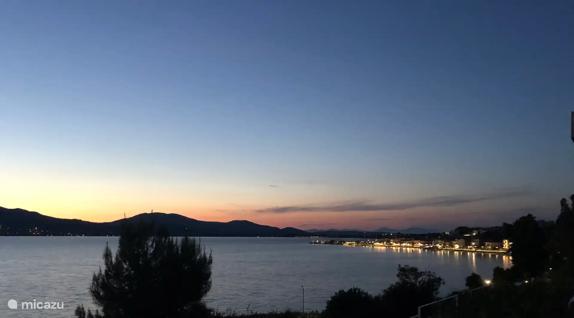 View of the town from the balcony at night. The harbor and the lights in the promenade