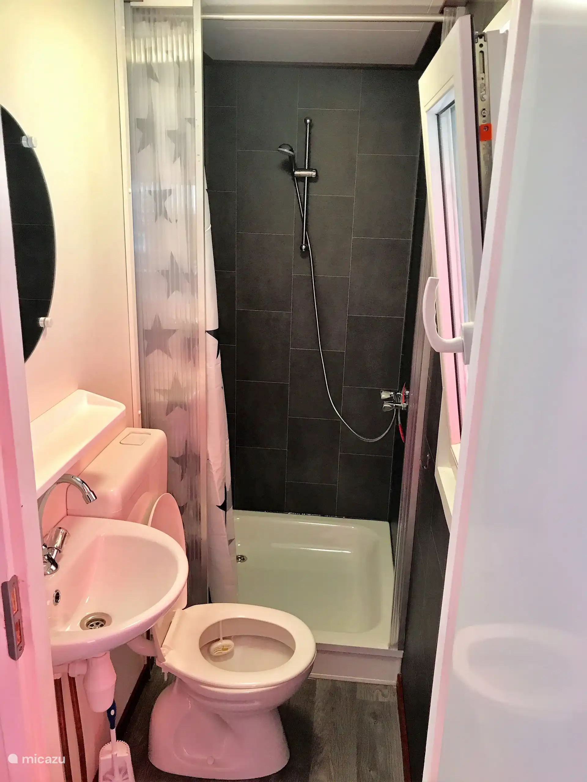 Badezimmer mit Dusche, WC und Waschbecken.