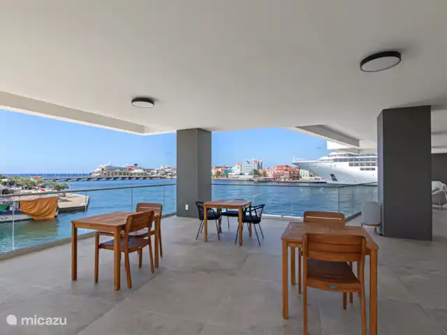The Wharf 1D - au cœur de Willemstad | Curaçao, Curaçao-Centre, Willemstad - appartement Terrasse extérieure partagée, avec une vue magnifique sur l’entrée du port, le pont flottant et la ville.